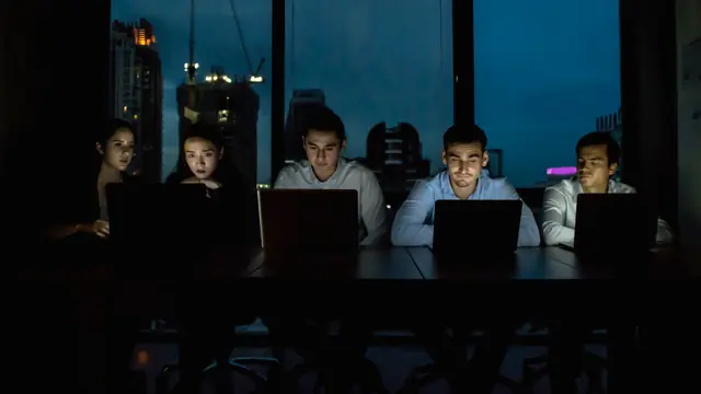 Mitarbeiter arbeitet am modernen Arbeitsplatz mit mehreren Bildschirmen
