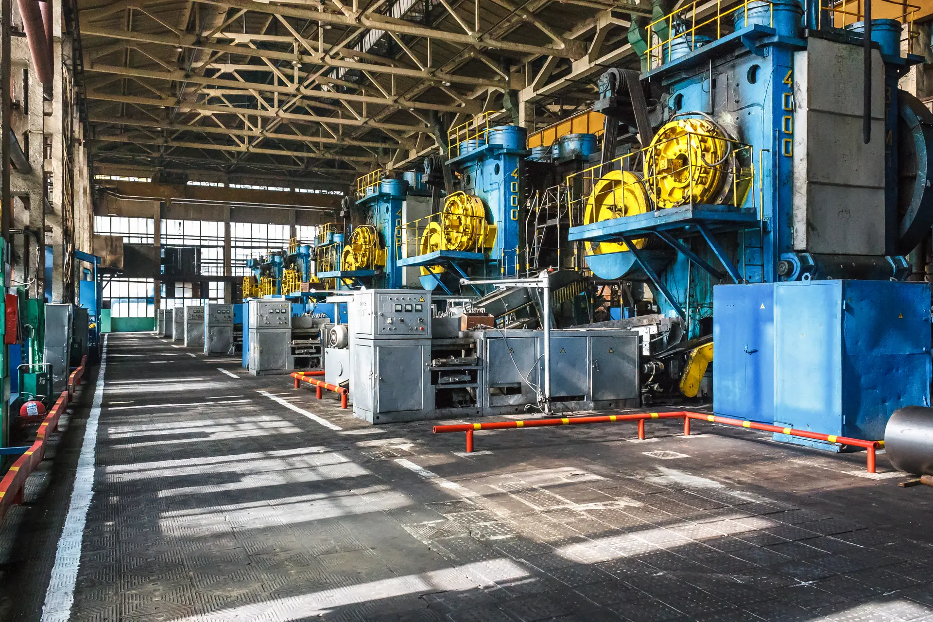 Werkshalle mit blauen Pressen und Maschinen in einer Industrieanlage